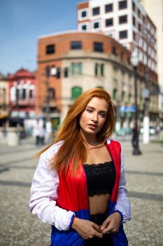 一位年轻时尚的红发女子在城市中摆姿势