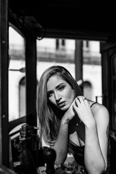 Artistic black and white portrait of a woman posing indoors in Santos, Brazil.