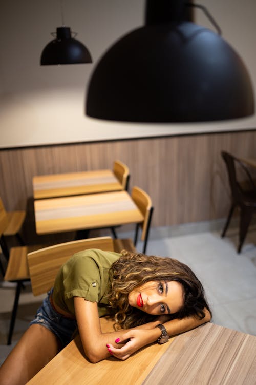 High Angle Photo of Woman Leaning on Table