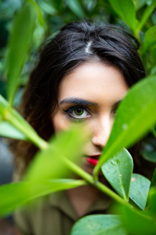 Close Upfoto Van Het Gezicht Van De Vrouw Dichtbij Bladeren