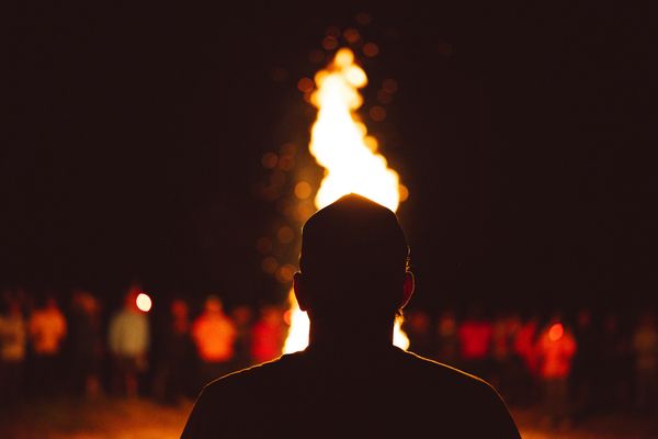 Figure silhouetted against a bonfire at night — photo by Joshua Eghelshi on Pexels