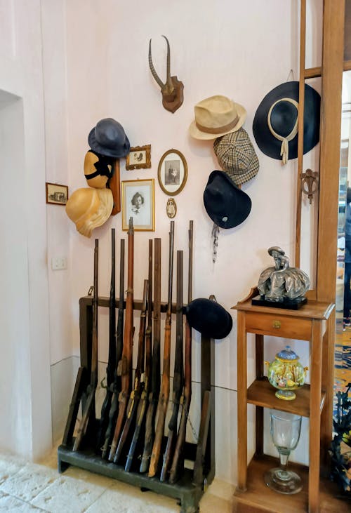 A room with many hats and guns on display
