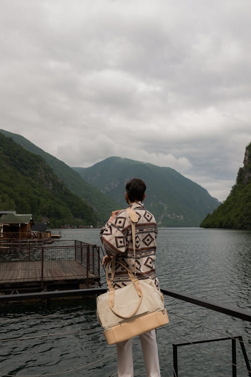Jovan Vasiljević standing near the lake looking at the mountains beyond 