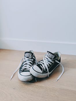 两款经典黑色运动鞋配上白色鞋带，非常适合休闲风格