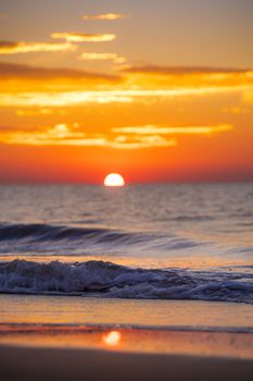 Stunning sunset at Hilton Head Island with vivid orange hues reflecting on ocean waves and sandy beach.