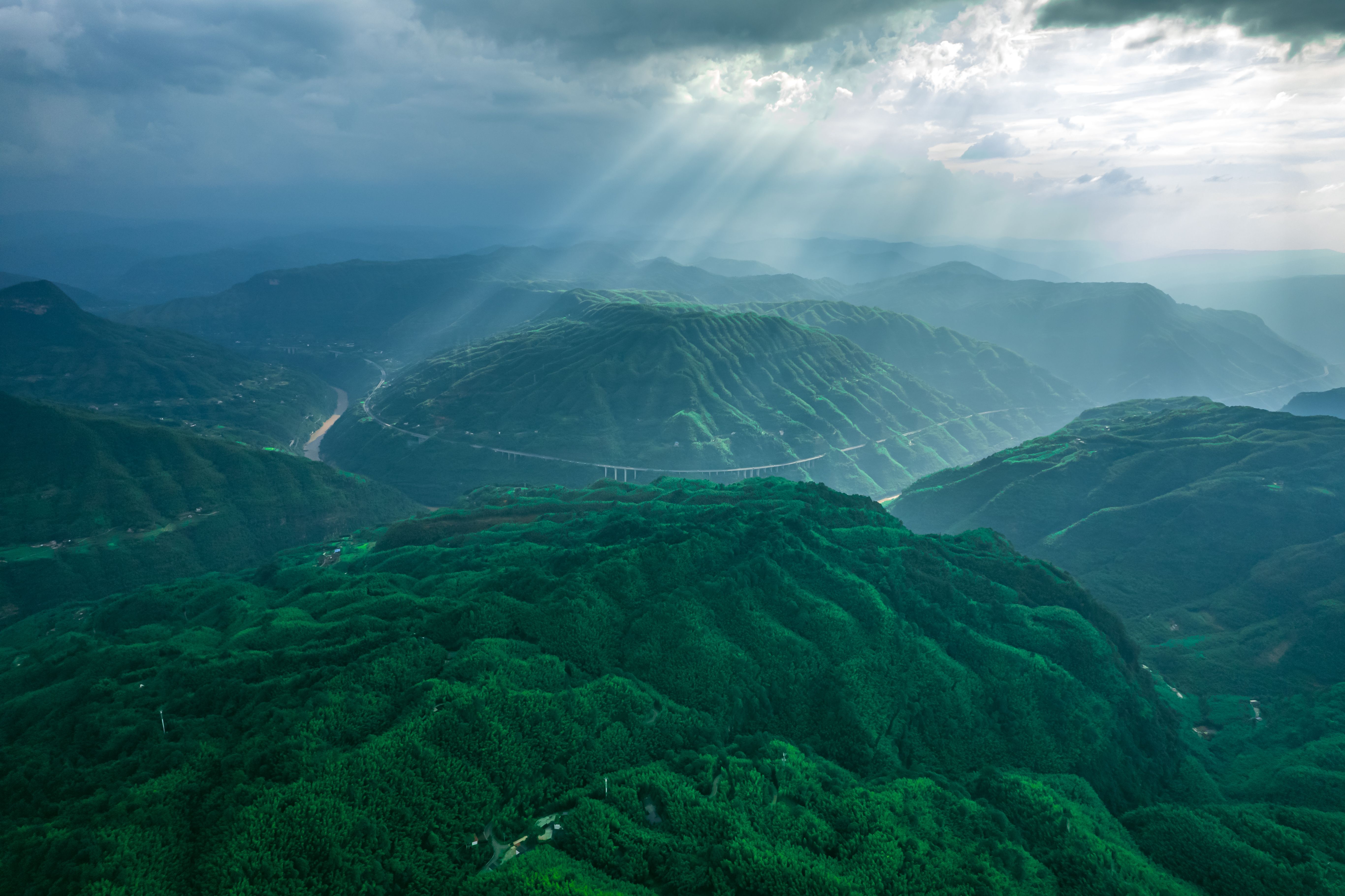 Aerial View of Green Mountains under a Cloudy Sky · Free Stock Photo