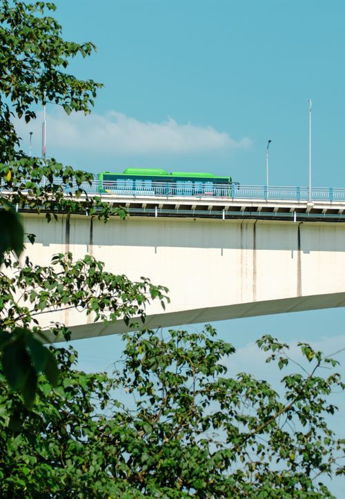 Free A green bus travels along an elevated bridge in Luzhou, Sichuan Province, China, under a clear blue sky. Stock Photo