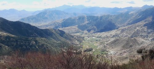 Free Expansive view of a scenic mountain valley with layered peaks and lush greenery. Stock Photo