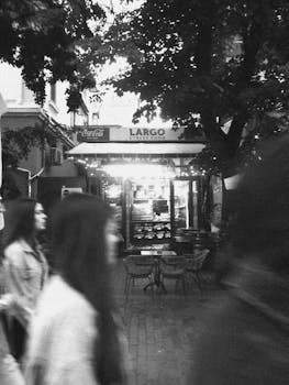 A lively street food scene with motion blur captures urban vibrance in black and white.