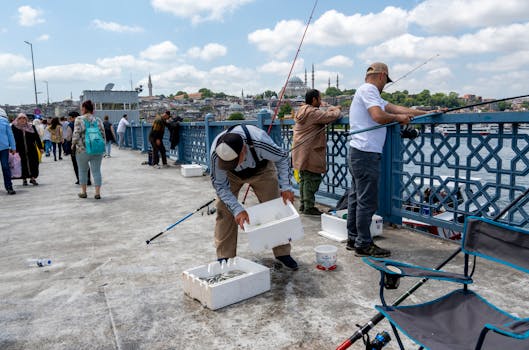 People fishing and enjoying leisure on the iconic Galata Bridge in Istanbul, Turkey.