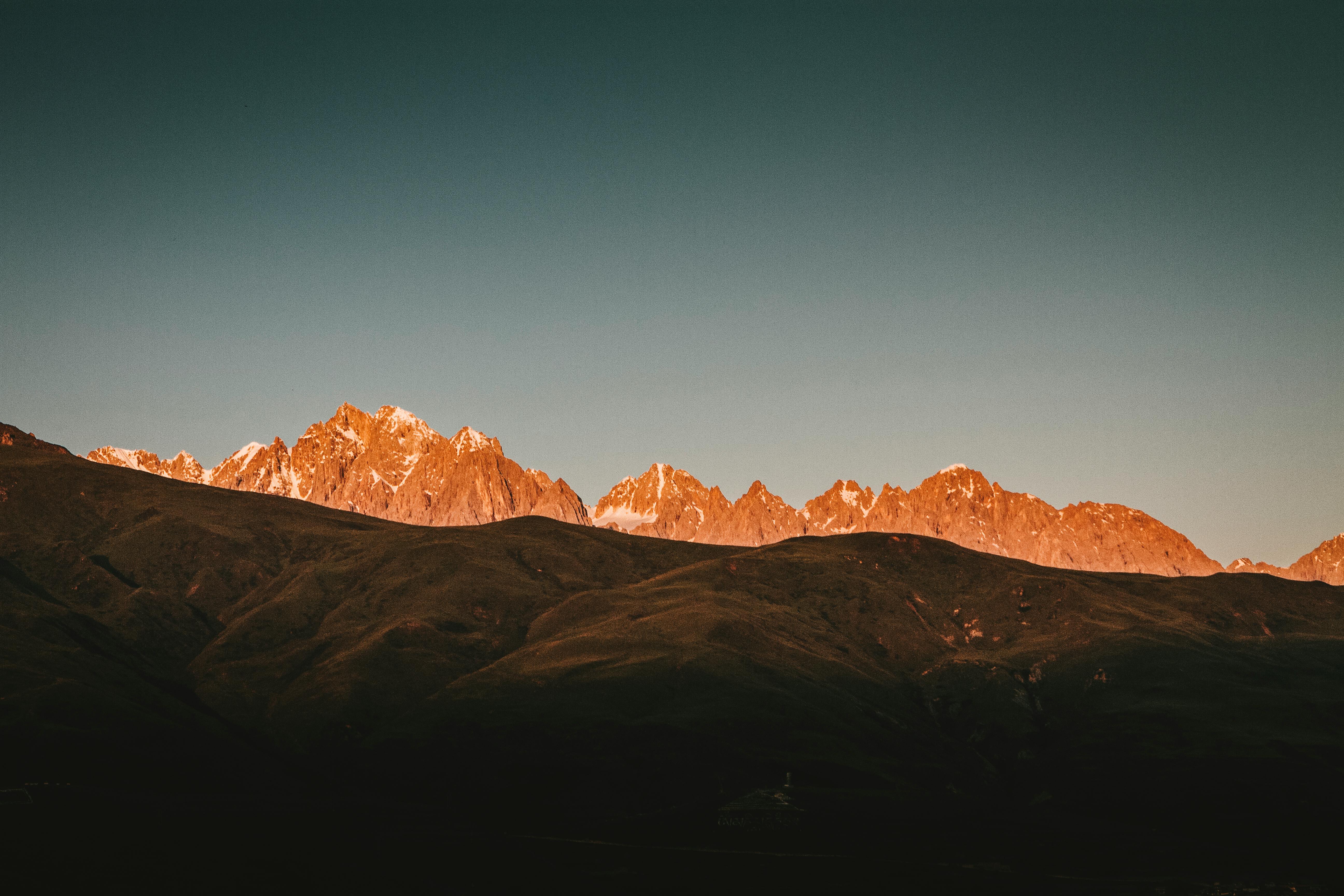 黎明的光芒照亮了令人惊叹的山峰，投下戏剧性的阴影
