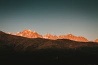 黎明的光芒照亮了令人惊叹的山峰，投下戏剧性的阴影