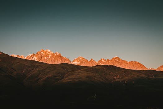 黎明的光芒照亮了令人惊叹的山峰，投下戏剧性的阴影