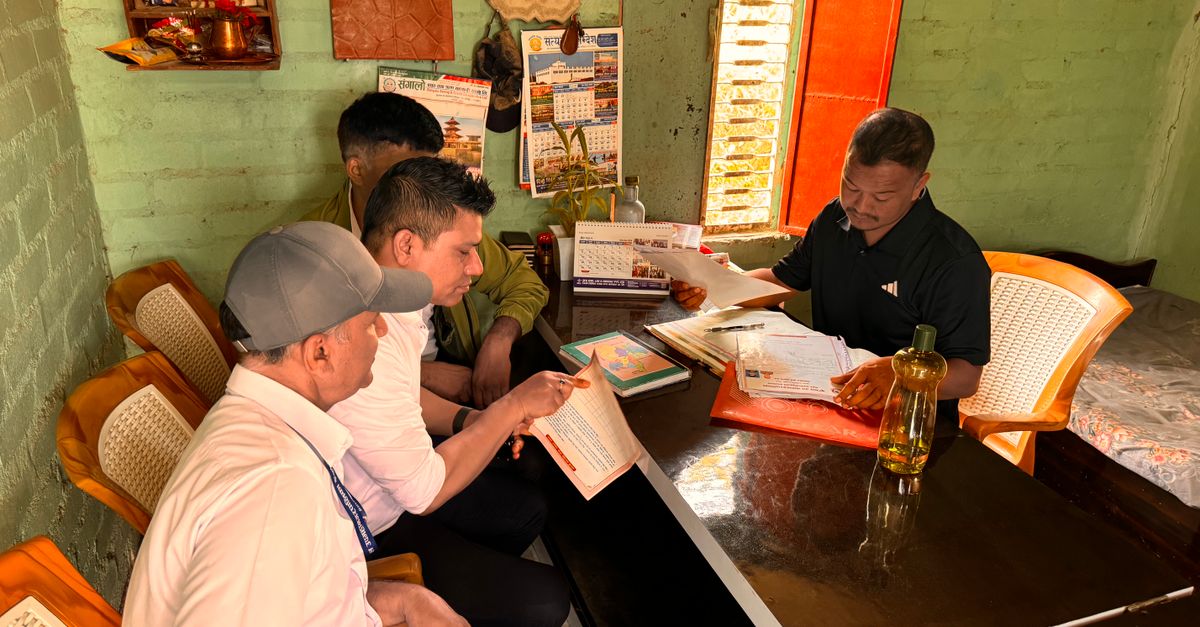 Men working together in a cozy office space with documents and calendars visible.
