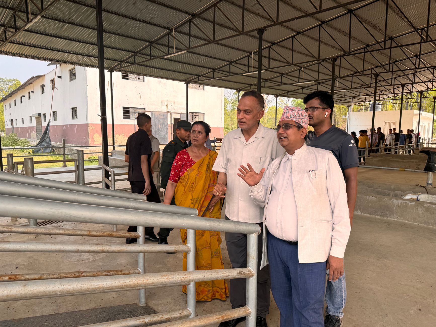 A group of people visiting a rural industrial site, discussing the surroundings.