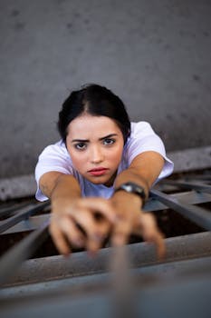 一名黑发女子伸手触碰金属结构，展现出力量与专注