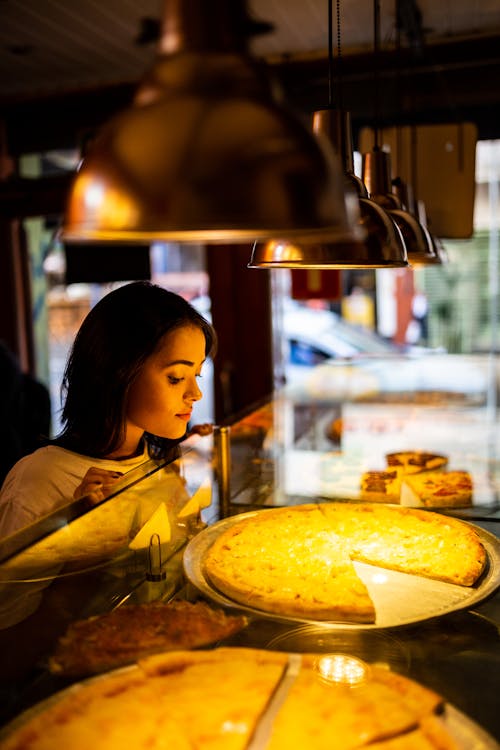 Foto Der Frau, Die Pizza Betrachtet