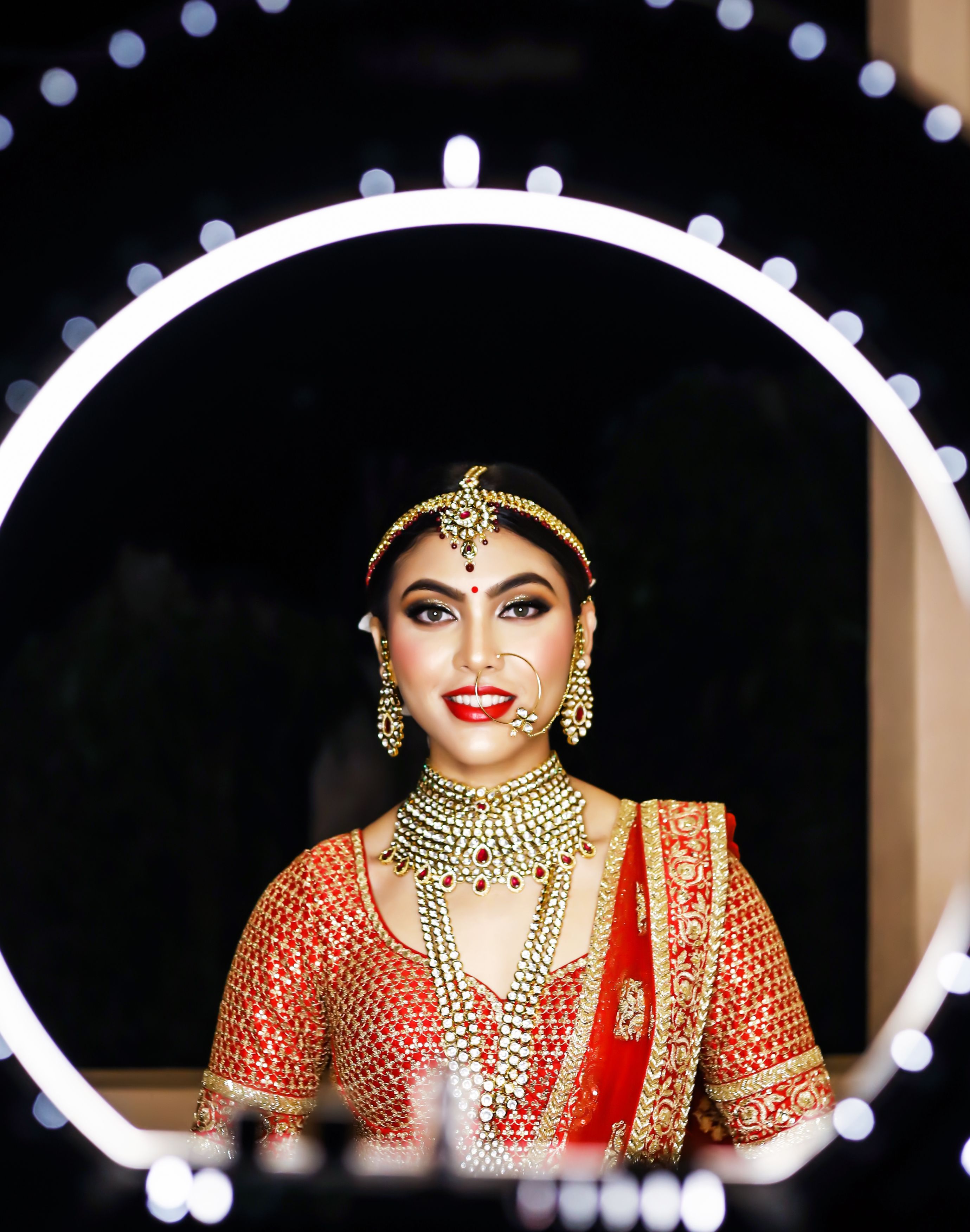 Stunning portrait of a South Asian bride in vibrant traditional clothing and jewelry.