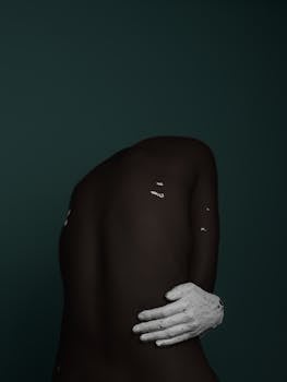 Conceptual art of black skin with white paint in a studio setting.