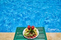 泳池边有两种清爽的草莓水果饮料，为夏日增添了活力氛围