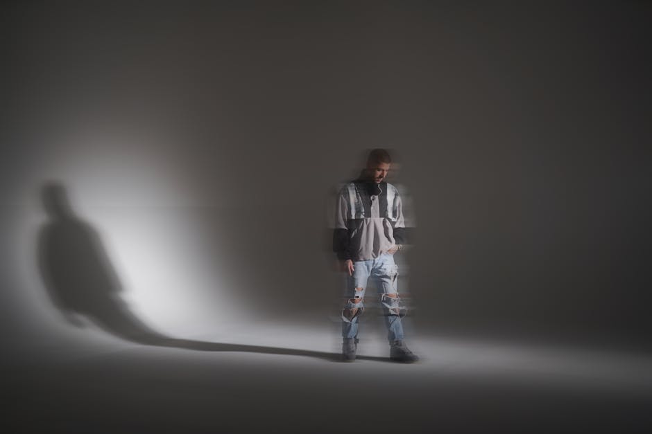 Artistic blurred fashion portrait of a man in a studio with torn jeans and a jacket.