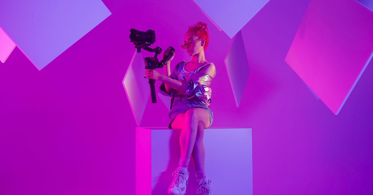 Young person in bedroom with recording equipment, colorful LED lights