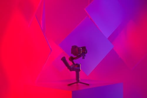 A camera on a tripod in front of a colorful background