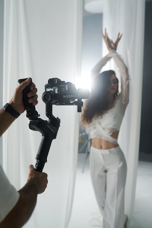 A woman is holding a camera and a man is holding a camera