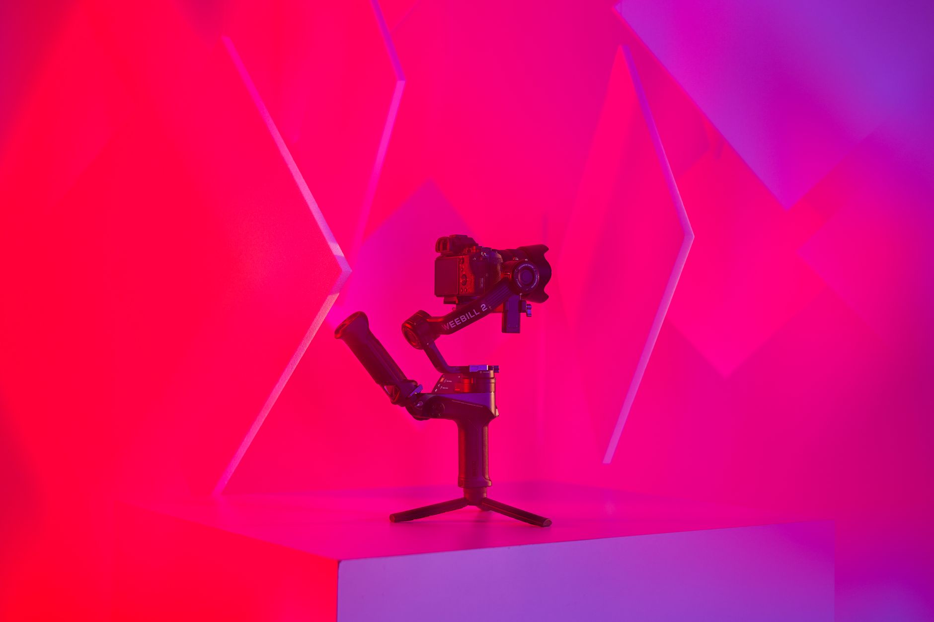 手持 vs 雲台:穩定器使用時機與選購指南 Vibrant studio image featuring a modern camera gimbal setup against abstract color background.