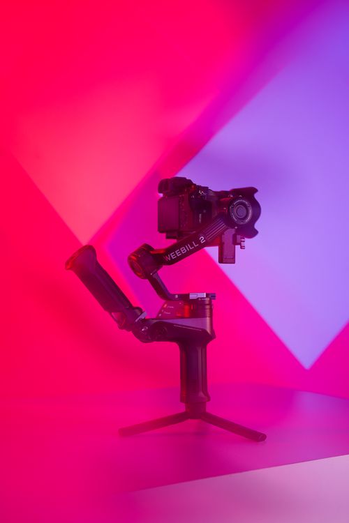 Free Camera gimbal in vibrant lighting, showcasing modern videography tools. Stock Photo