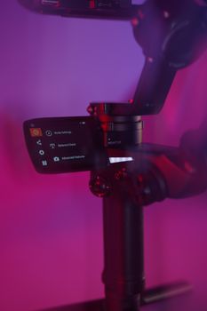 Detailed shot of a camera gimbal displaying settings on its control screen.