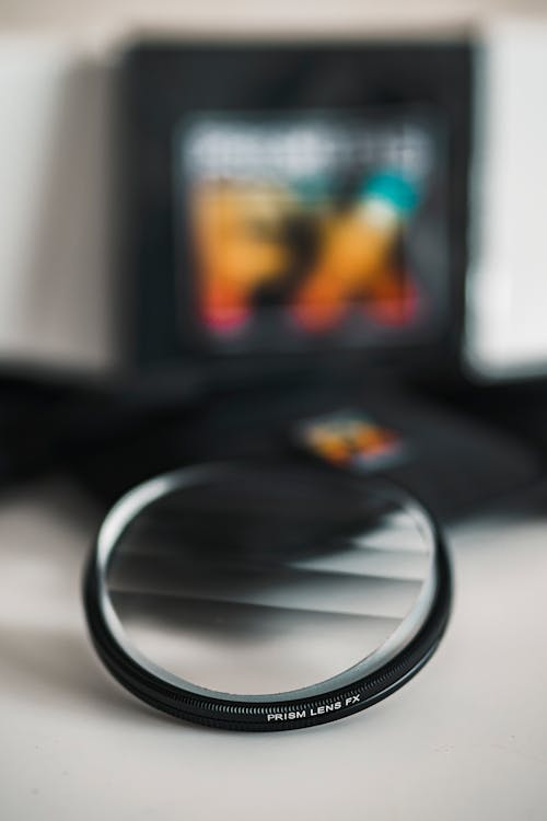A lens filter with a black case next to it
