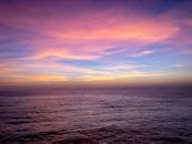 纽波特海滩海洋上美丽的日落，呈现出鲜艳的粉色和紫色色调