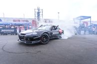 Exciting drifting event featuring a Nissan Silvia S15 with smoking tires and spectators.