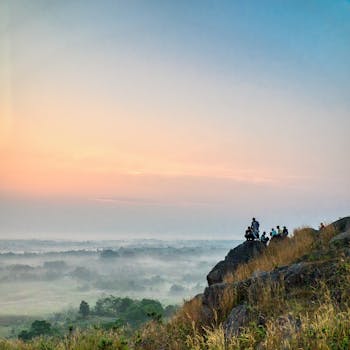 在西爪哇岛，一群徒步旅行者在山顶欣赏薄雾般的日出