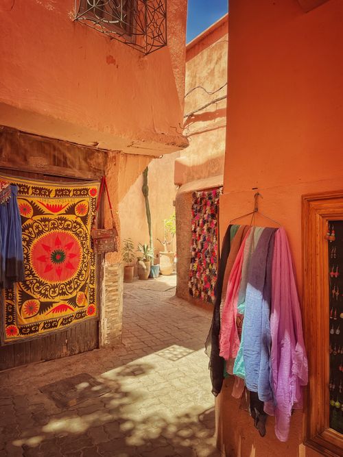 Free Explore a historic alley featuring vibrant textiles and warm architecture. Perfect stock photo for cultural themes. Stock Photo