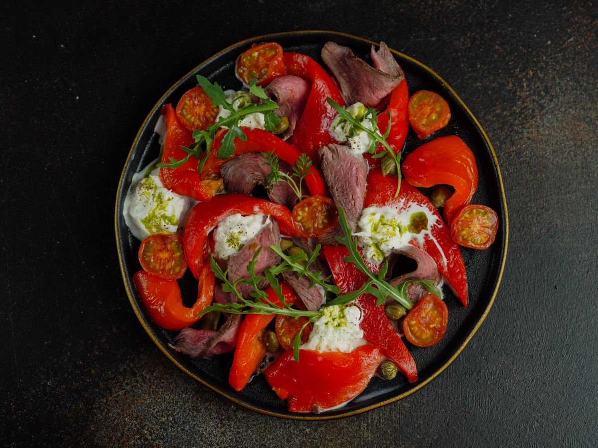 Salad of roasted peppers, flaked fish and fresh herbs on a plate — photo by Nadin Sh on Pexels