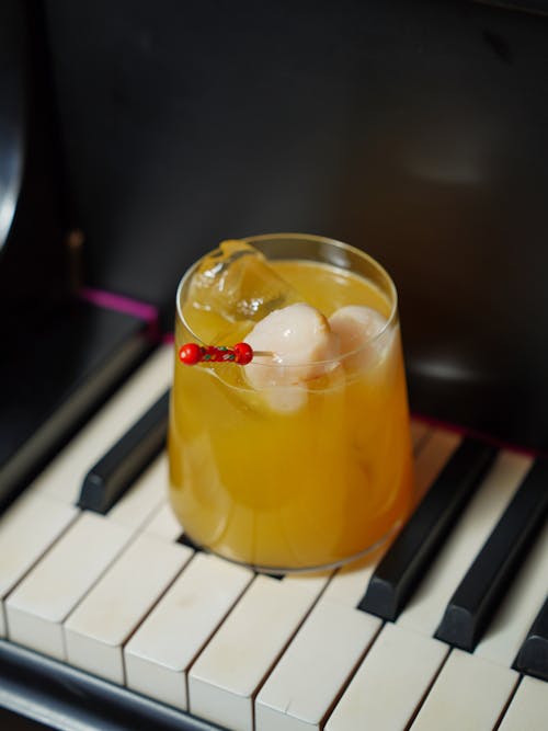 A cocktail with a cherry on top sitting on top of a piano