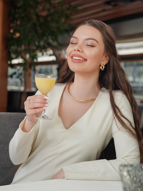 A woman drinking a glass of orange juice