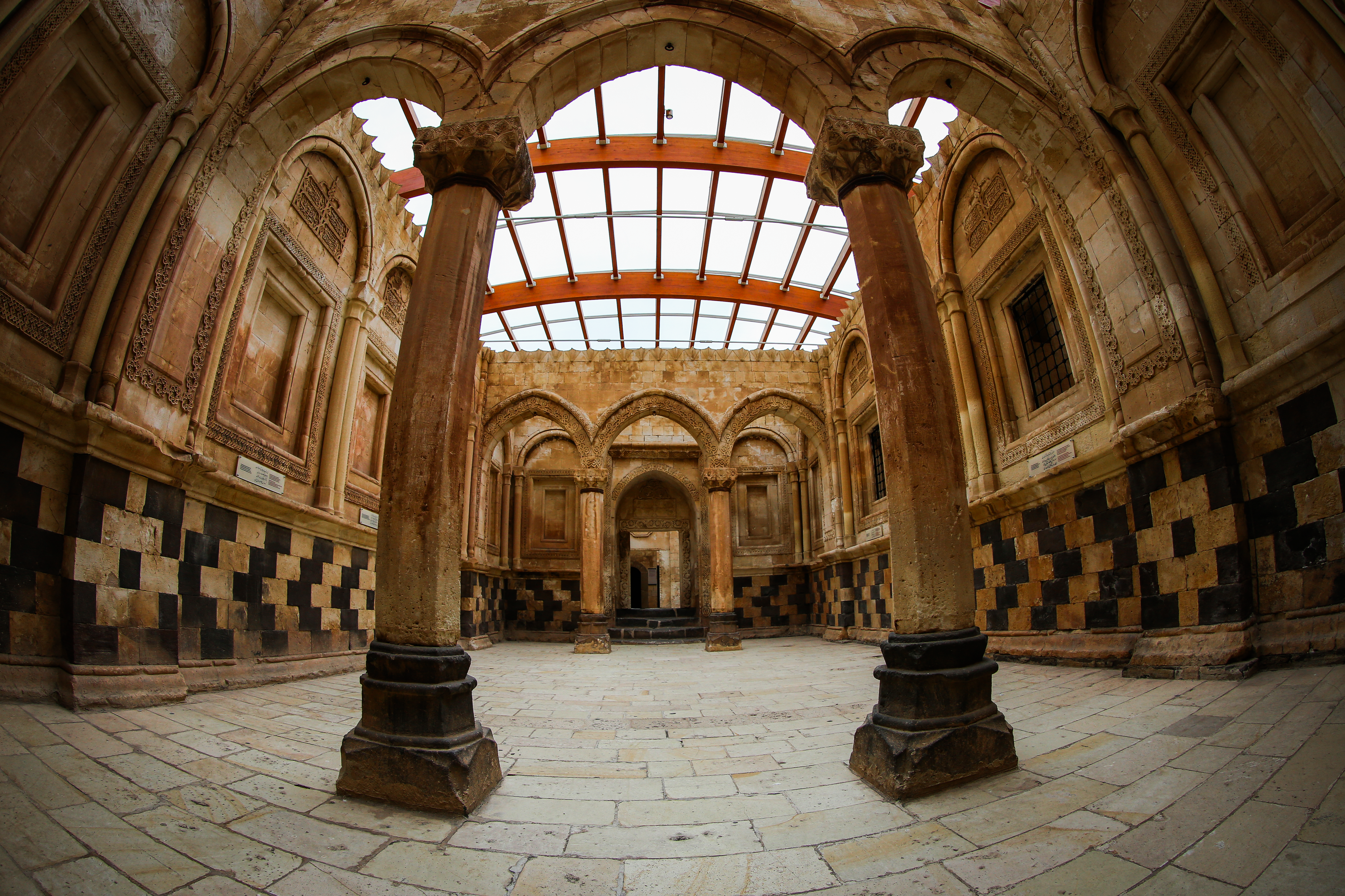 Wide-angle view of the ornate Ishak Pasha Palace interior showcasing Ottoman architecture in Doğubayazıt, Türkiye.