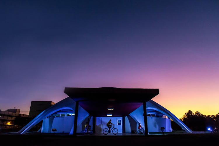 Photo Of People Riding Bike Near Building