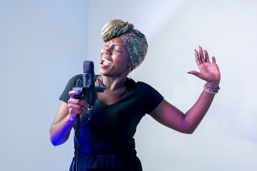 Cantora em estúdio diante de um microfone
