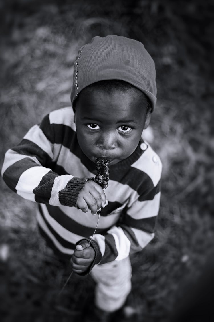 Monochrome Photo Of Kid Eating