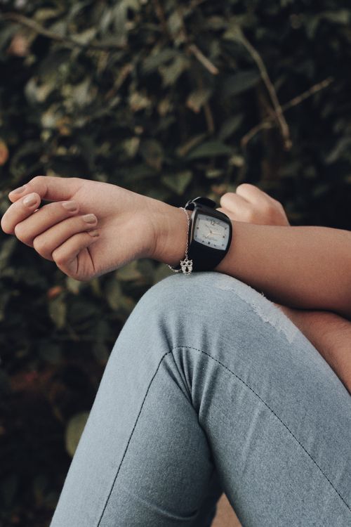Free A person relaxes outdoors wearing a wristwatch, showcasing time and casual style. Stock Photo