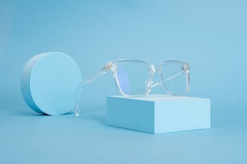 Free Minimalist Chic: Clear Eyeglasses Displayed on Blue Background Stock Photo