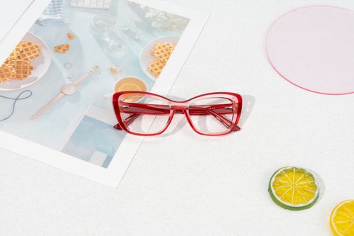 Free Red glasses on a magazine with citrus slices, creating a vibrant, stylish vibe. Stock Photo