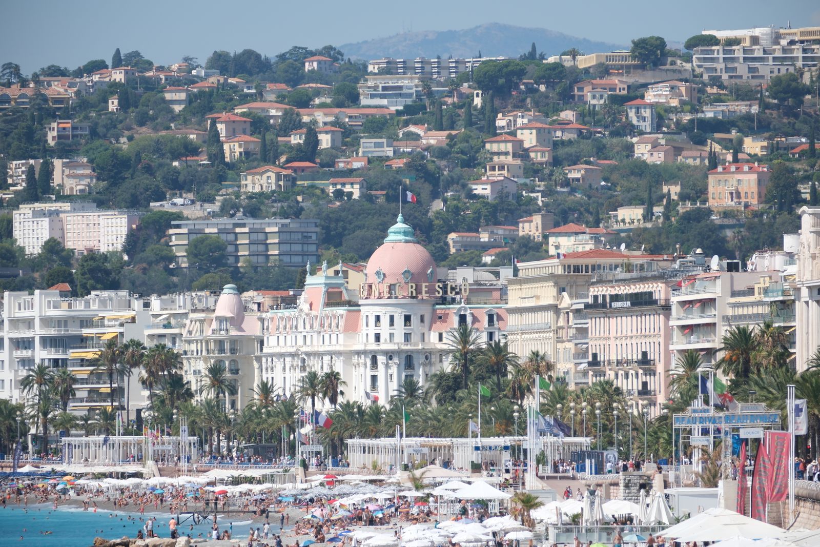 View of the famed beaches and luxurious hotel in Nice, France, during a vibrant summer day.