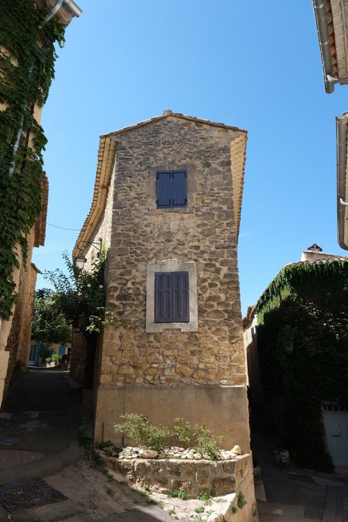 Free Vertical shot of a narrow stone house on a sunny street in a picturesque old town. Stock Photo