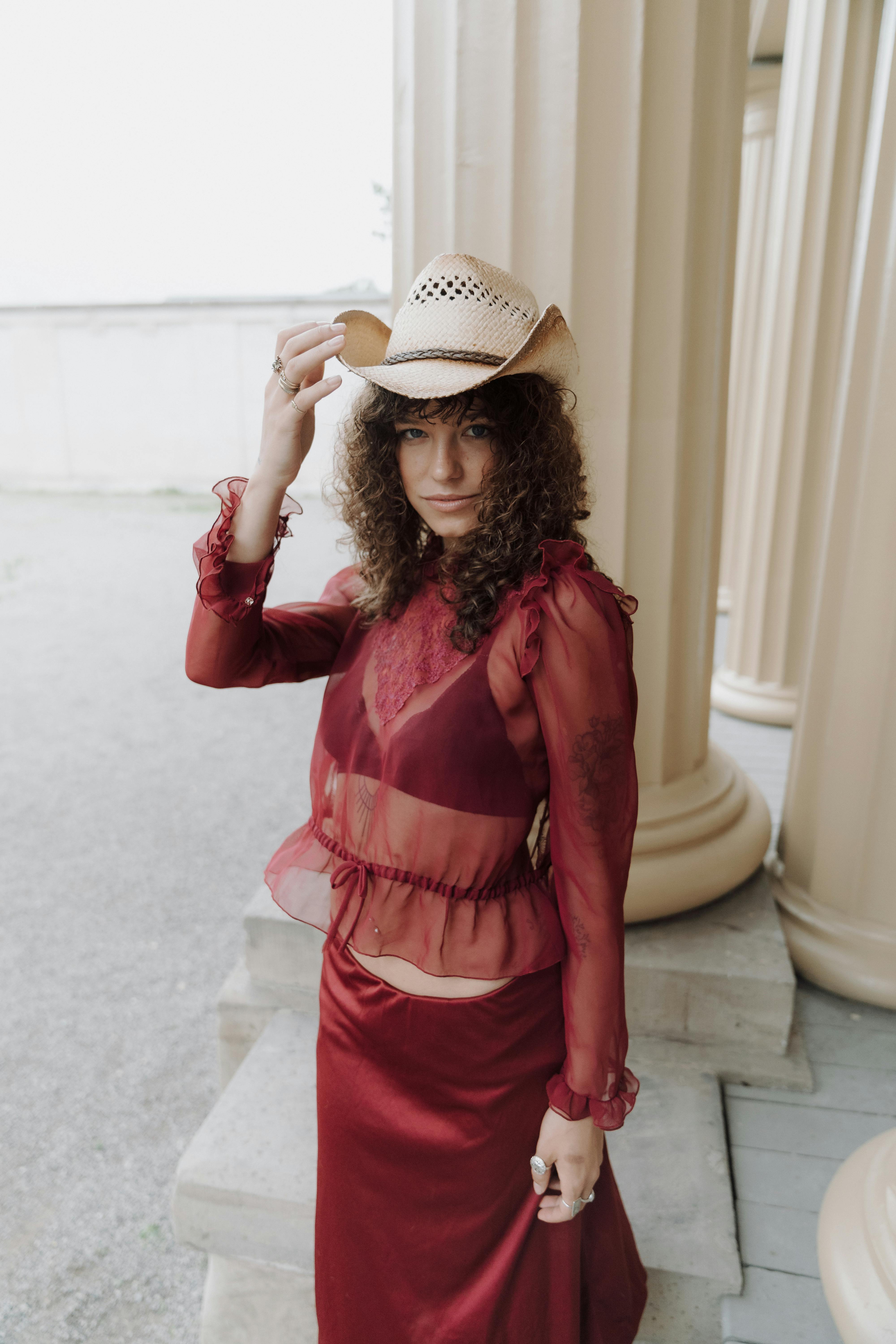 a woman in a red dress and cowboy hat