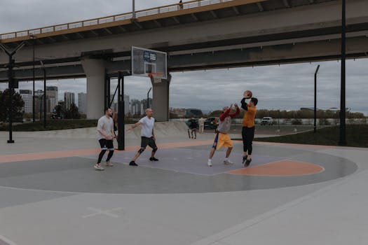 Casual basketball game played under a city bridge, showcasing urban sports culture.
